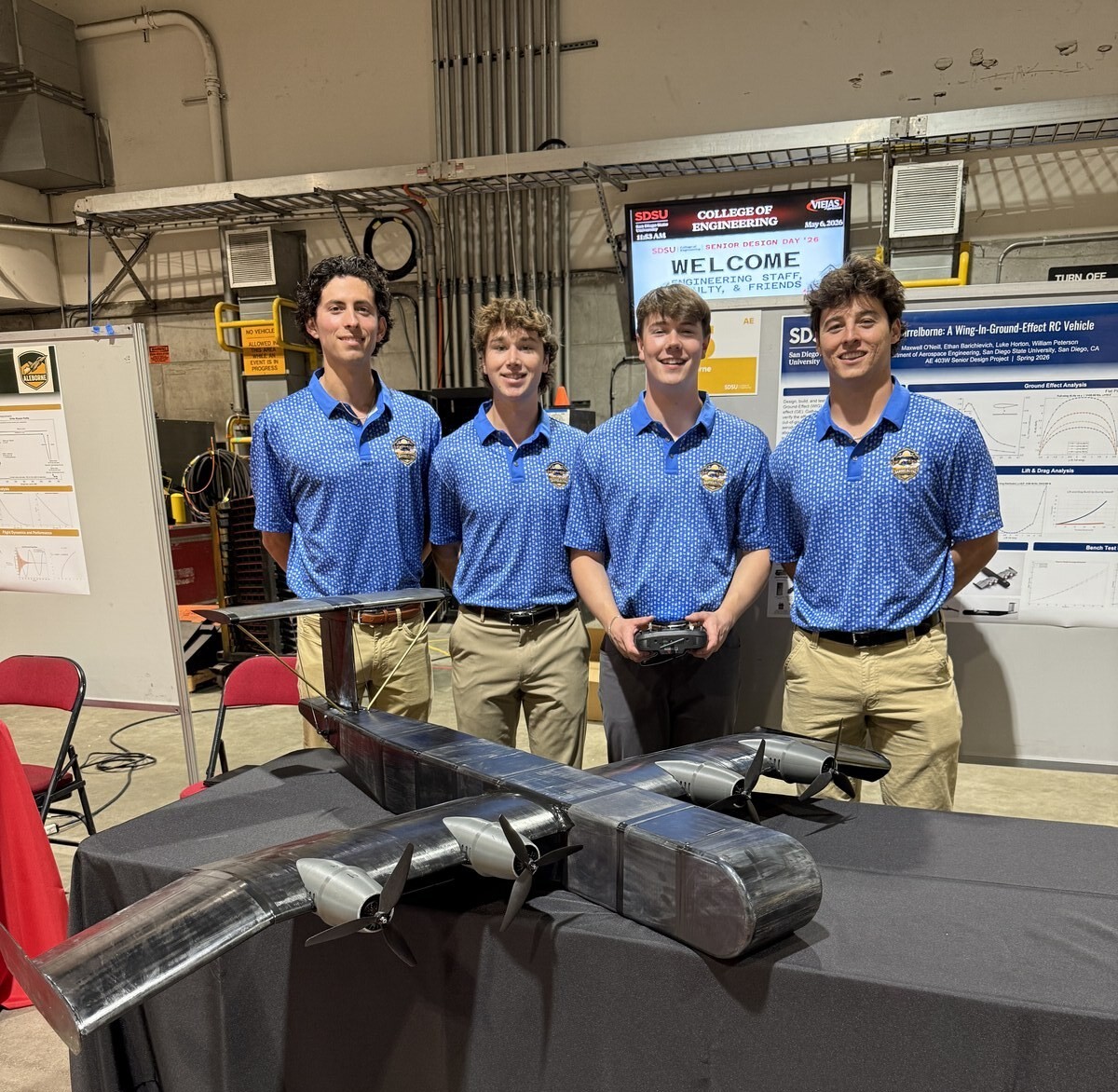 The four-person BarrelBorne team standing behind the completed WIG vehicle at SDSU Senior Design Day, May 6, 2026.